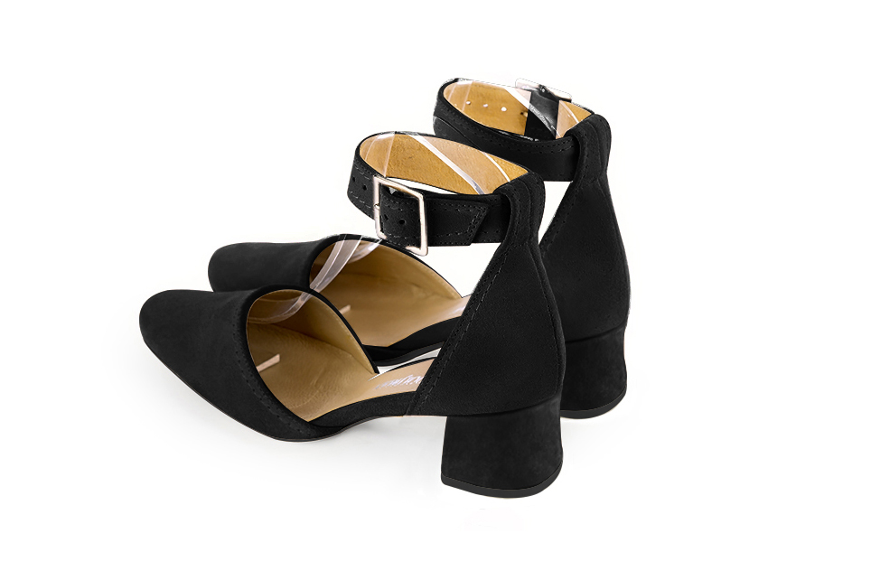 Women's matt black open side dress shoes, with a strap around the ankle. Round toe. Low flare heels - Rear view